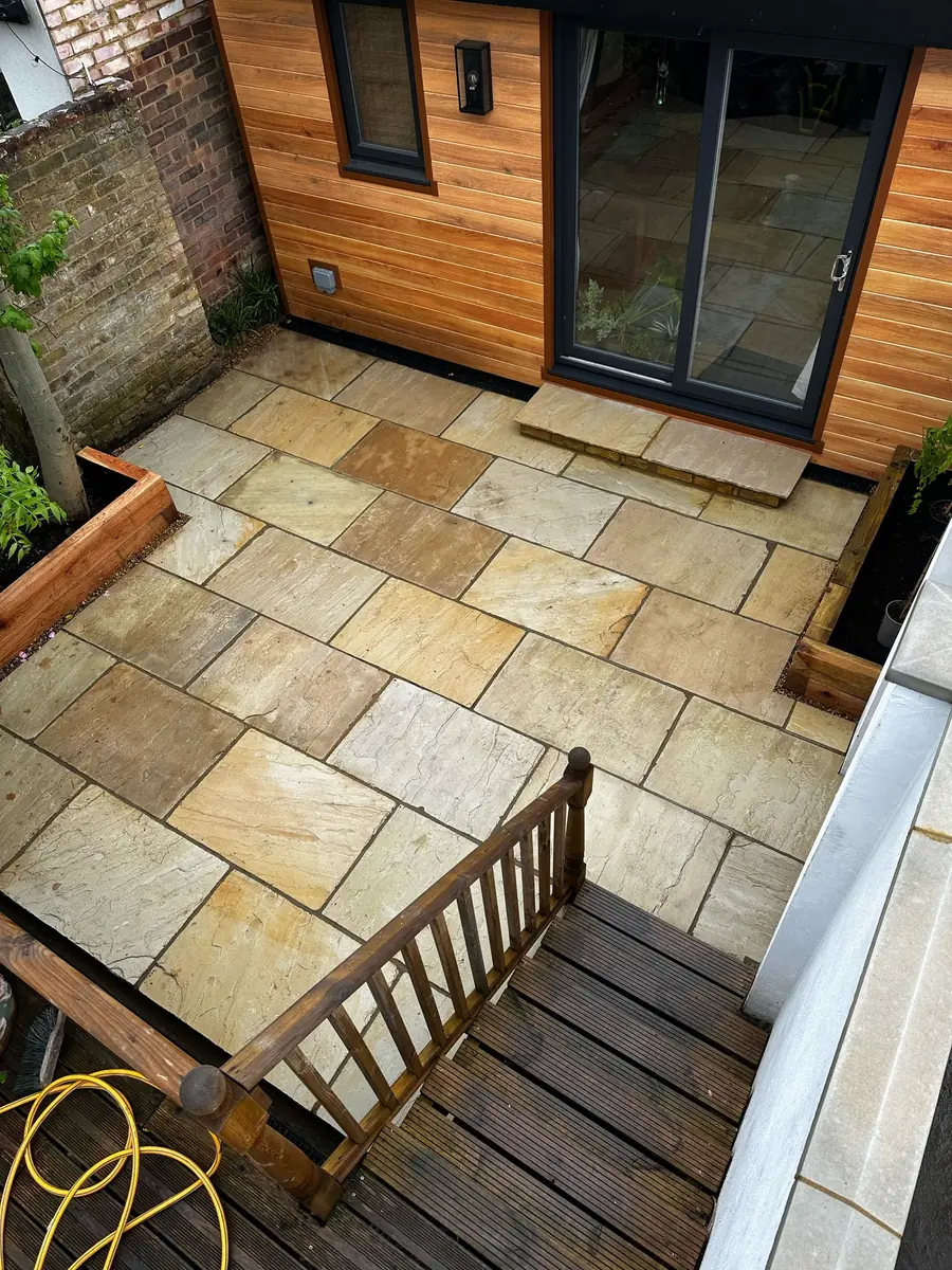 After: sandstone courtyard with oak sleeper planters, seen from the deck above