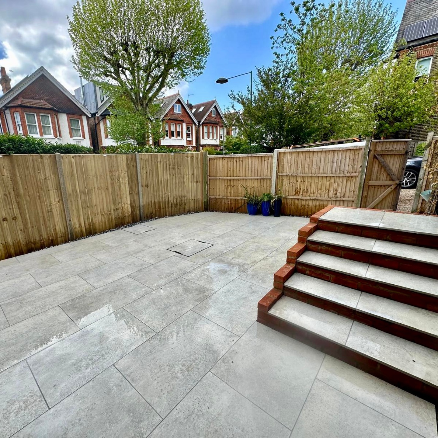 Porcelain patio with brick faced steps and new fencing in a Kingston upon Thames garden