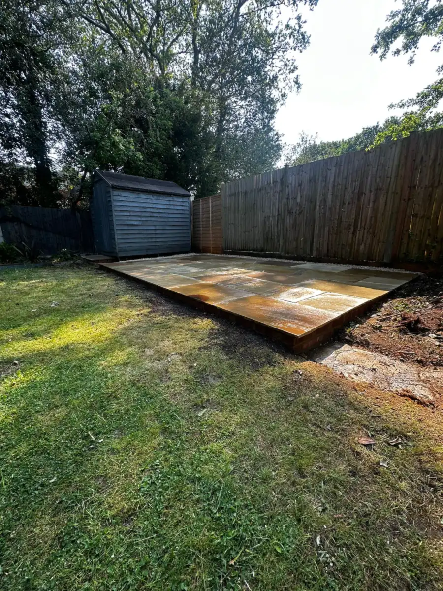 Mint sandstone patio laid beside a timber shed against the back fence, Claygate