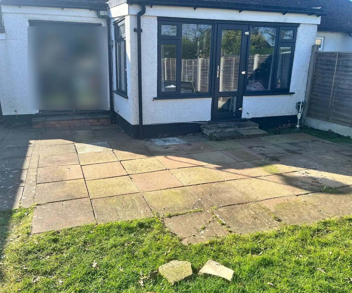 Before: cracked and stained concrete slabs across the back of a bungalow in Addlestone