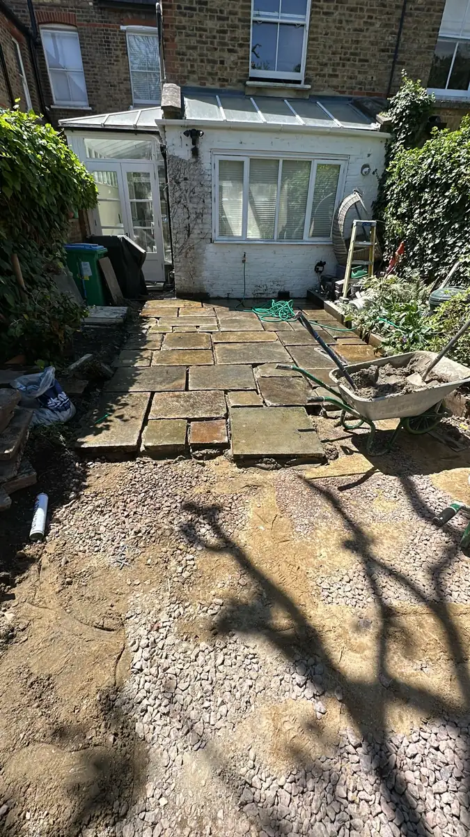 Excavated Kew garden with the original stone slabs stacked ready to relay
