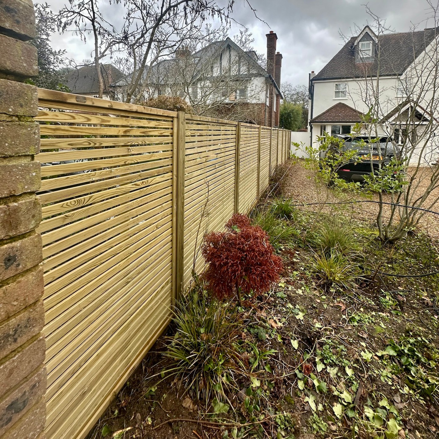 Venetian style slatted fencing installed along a garden boundary in East Molesey, Surrey
