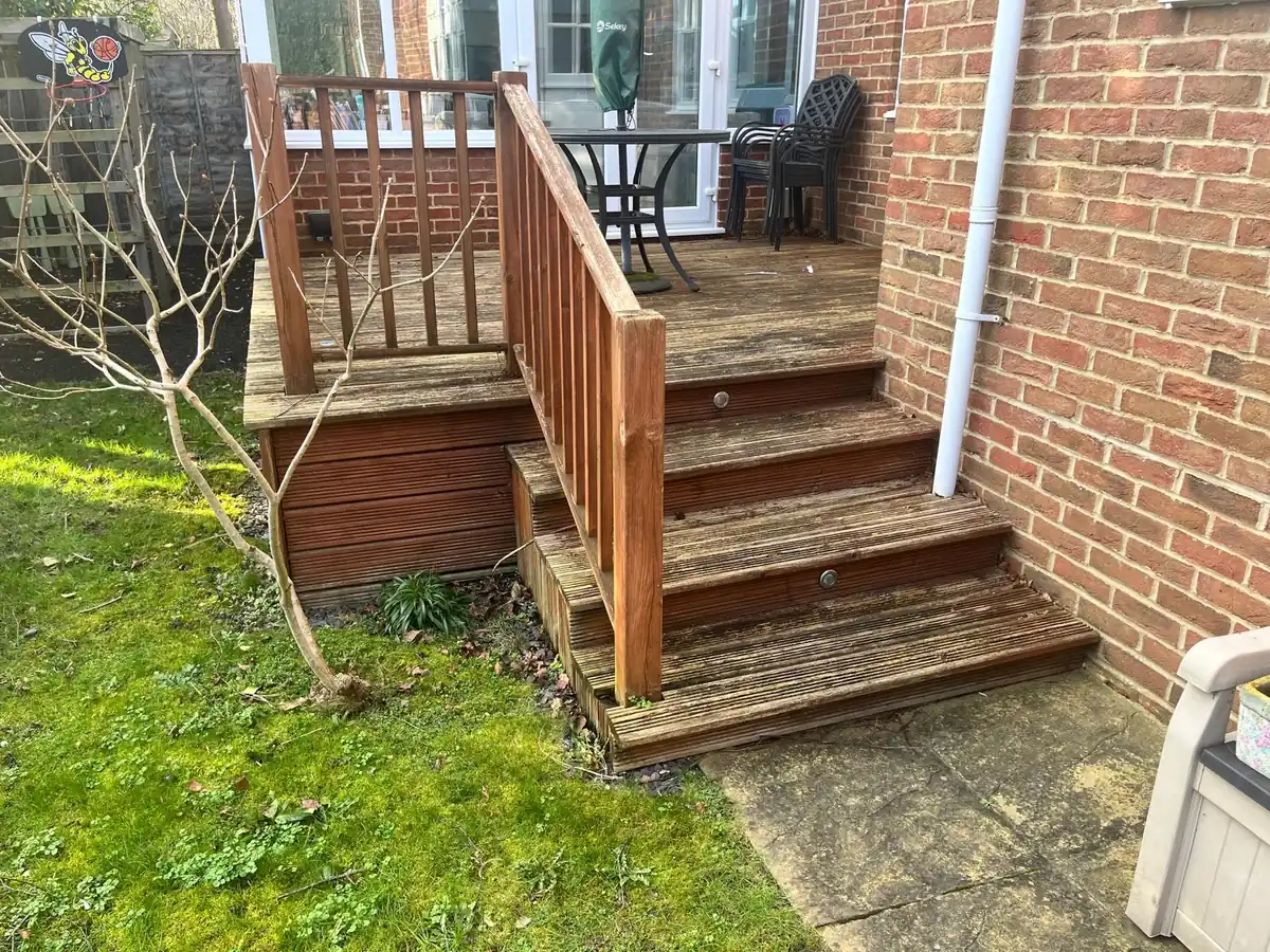 Before: weathered raised timber deck and steps at the back of a house in Esher