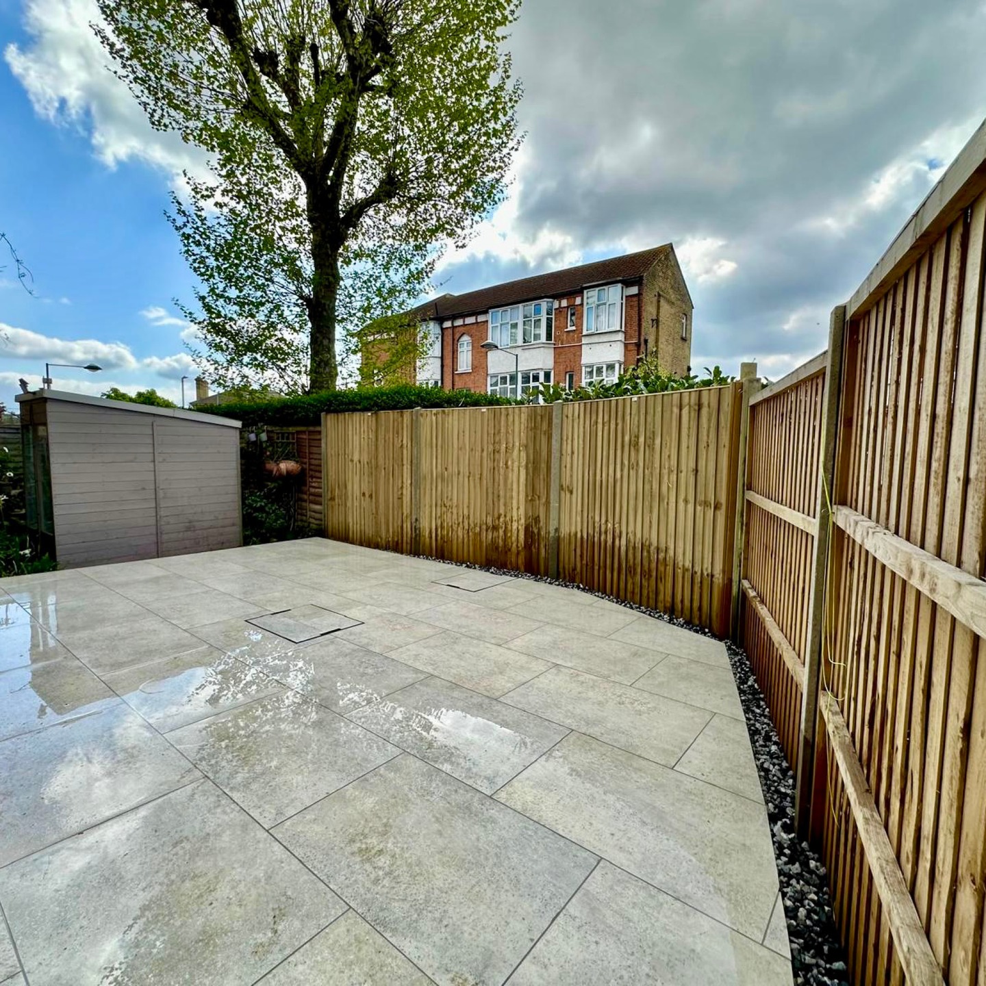 After: porcelain patio with a gravel margin and new close board fencing in Kingston upon Thames