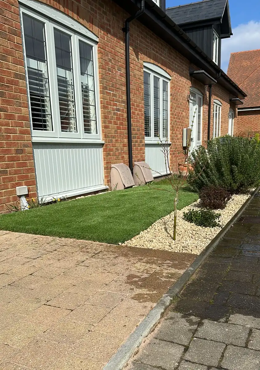 Finished front garden with artificial grass, Cotswold chippings and new planting in Bookham