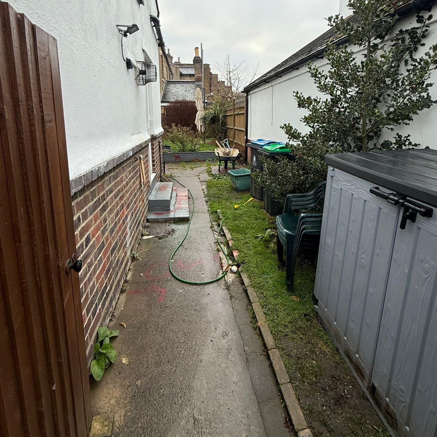 Before: broken concrete path and worn grass down the side return of the house