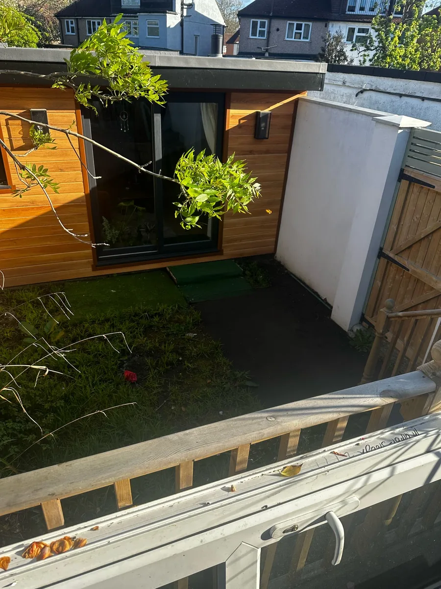 Before: patchy grass and bare soil in a small courtyard garden in Twickenham